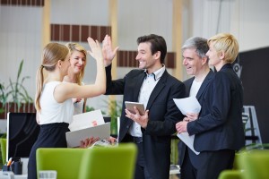 Successful team of business people giving high five in the offic
